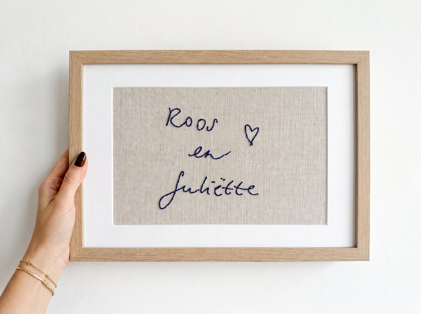 Framed embroidered piece reading "Roos en Juliëtte"